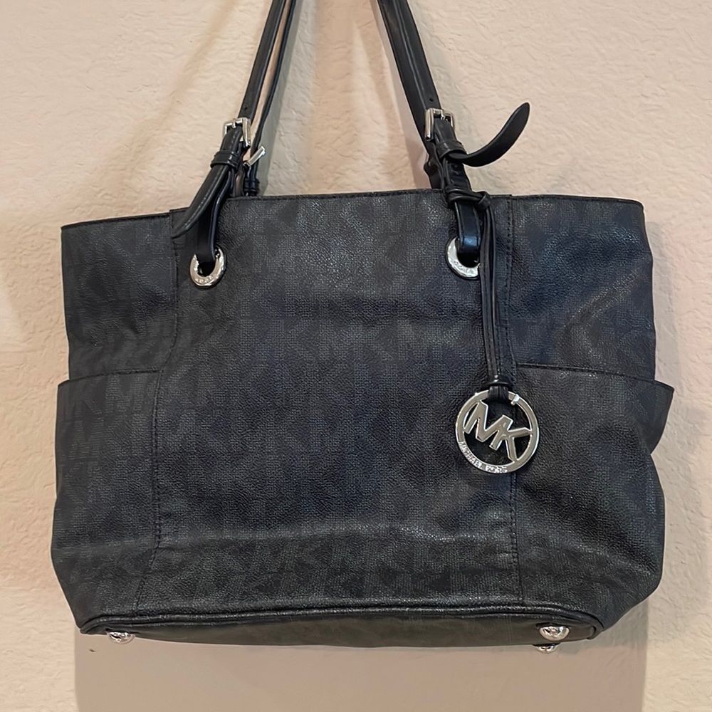 This is a black and silver Michael Kors shoulders purse.With lots of pockets
